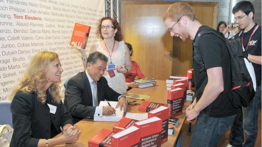 O profesor Eleuterio Toro, en presenza da profesora Vázquez Cendón (de pé detrás del), asina exemplares do seu manual O profesor Eleuterio Toro, en presenza da profesora Vázquez Cendón (de pé detrás del), asina exemplares do seu manual