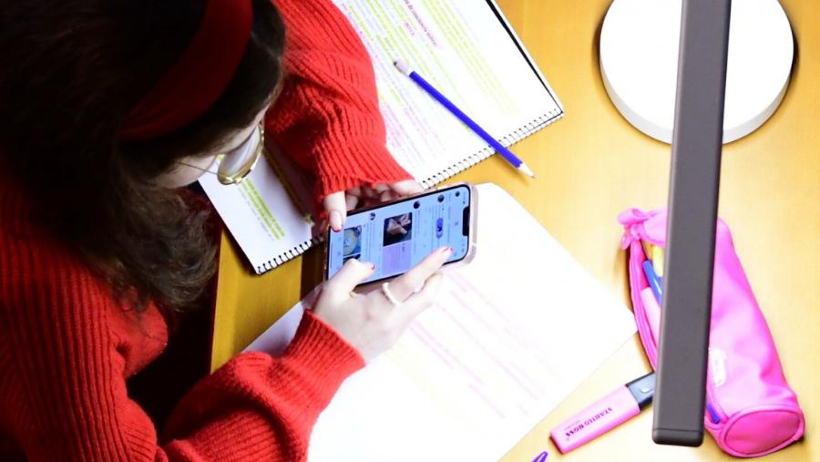 Alumnado consulta o móbil nun posto de lectura. Foto: Santi Alvite