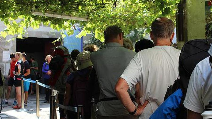 Detalle de peregrinos agardando para recoller a 'Compostelana'