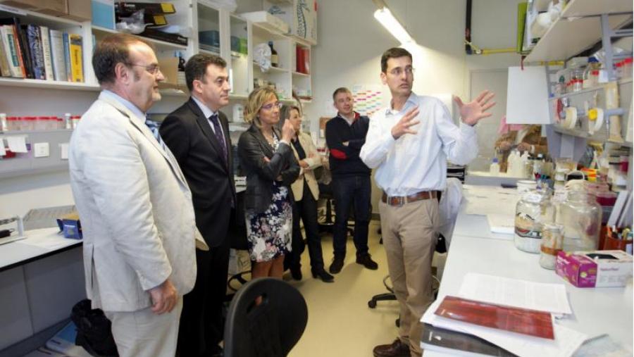 Rubén Nogueiras explica aos conselleiros detalles das investigacións realizadas no CiMUS en presenza da vicerreitora Isabel Rodríguez-Moldes, Pilar Garcés e Miguel López. Foto: Xunta de Galicia